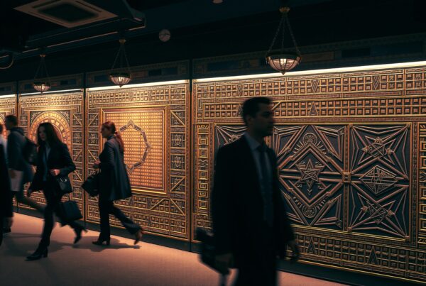 Professionals walking past ornate panels.