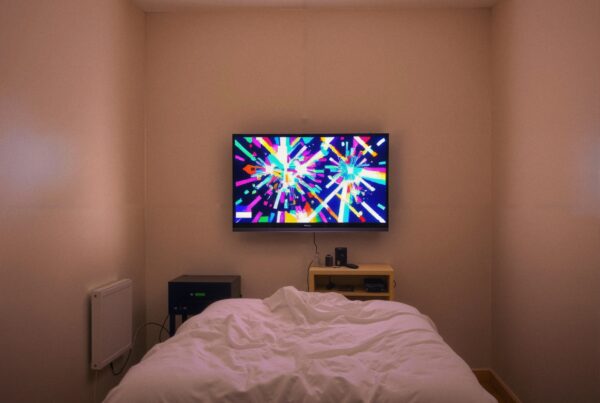 A cozy bedroom with a bed, abstract TV display, and modern décor.