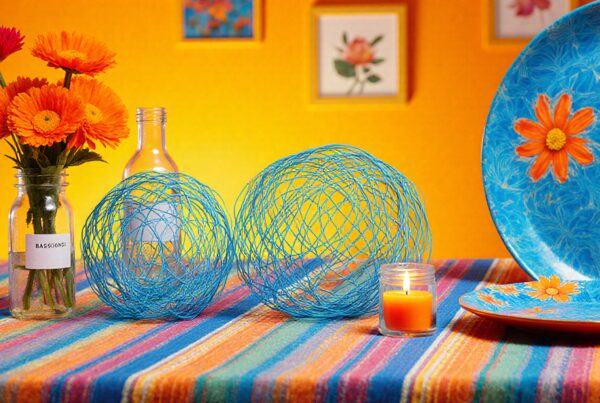 Vibrant flowers and decor on colorful table setting with warm yellow background.