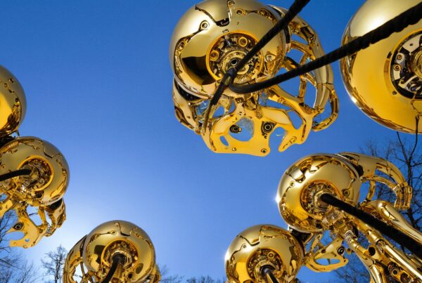 Golden robotic structures under blue sky.
