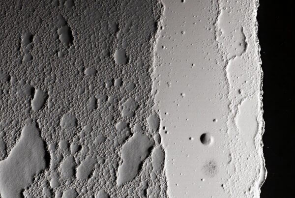Close-up of a textured lunar-like surface with craters.