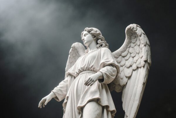 Majestic angel statue with detailed wings and serene expression against a dramatic cloudy background.