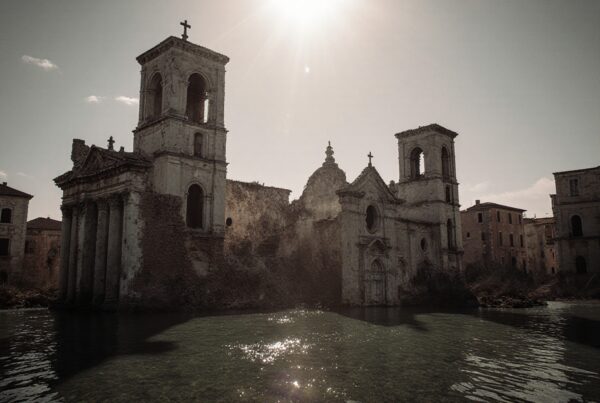 A sunlit, abandoned church with reflections.