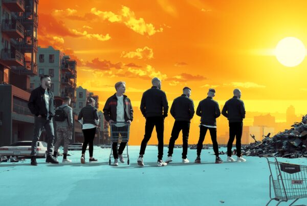 Silhouetted group under vivid sunset in urban setting.