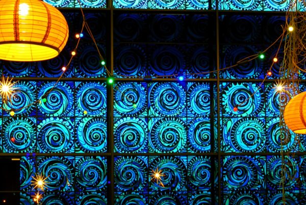Decorative stained glass window with orange paper lanterns and colorful lights.