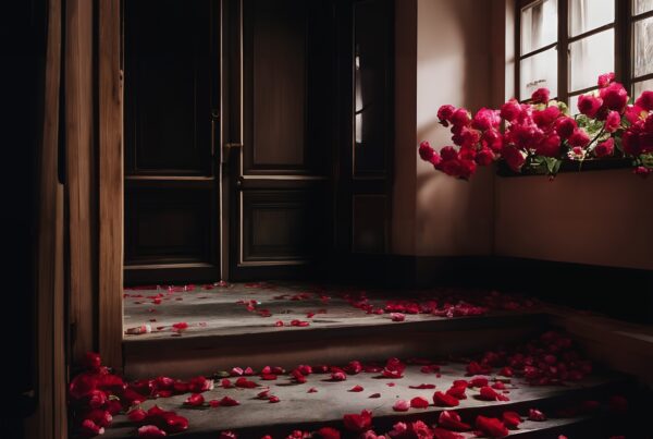 Dimly lit hallway with scattered rose petals leading up to wooden doors, enhancing a romantic and mysterious atmosphere.
