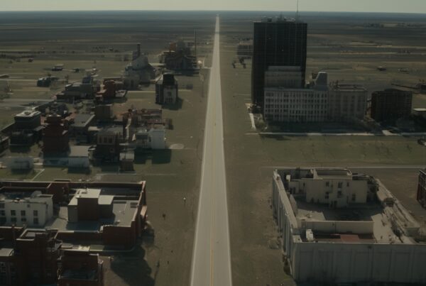 A long, empty road stretches through an abandoned town.