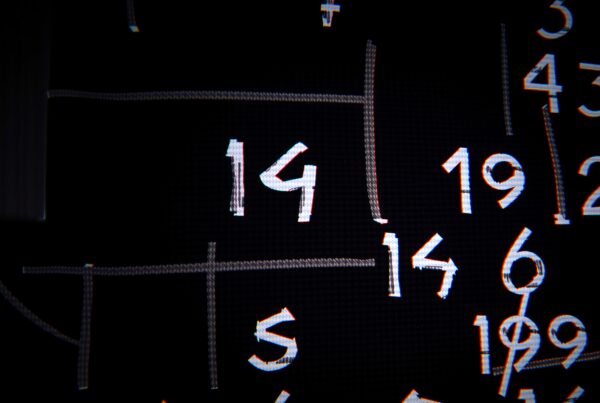 A chaotic grid of various chalk-drawn numbers overlapping and intertwining on a dark background.