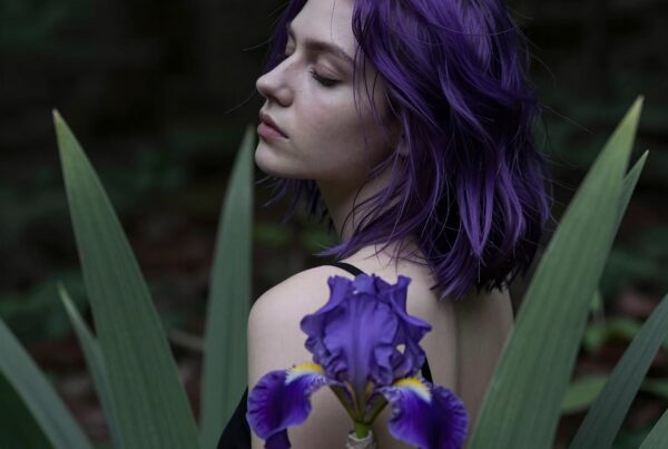 A woman with purple hair surrounded by lush greenery and a striking purple iris.