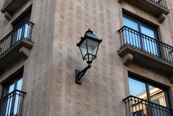 Architectural facade with decorative patterns and lamp.