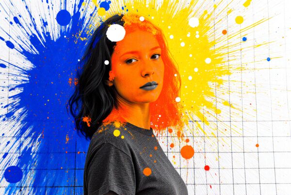 A woman stands in front of a vivid abstract painting with vibrant blue, yellow, and orange paint splatters.