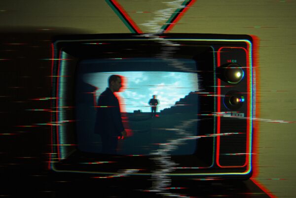 A retro television displays a distorted glitchy image of two figures against a blue sky.