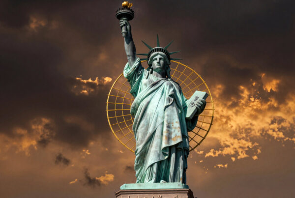 Statue of Liberty holding torch under dramatic golden sunset sky