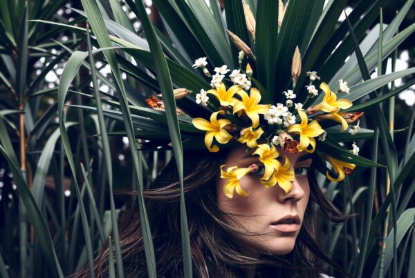 Woman wearing floral crown among tall green leaves in tranquil nature portrait