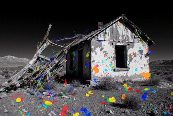 Abandoned house in desert painted with vibrant splashes.
