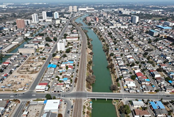 Cityscape with river dividing urban neighborhoods and railway lines