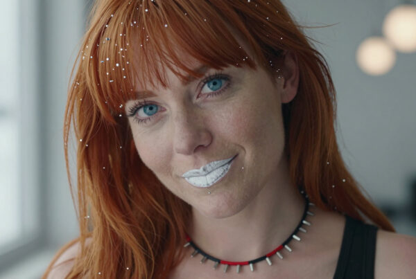 Woman with red hair wearing sparkling glitter and white lipstick posing for glamorous portrait photo