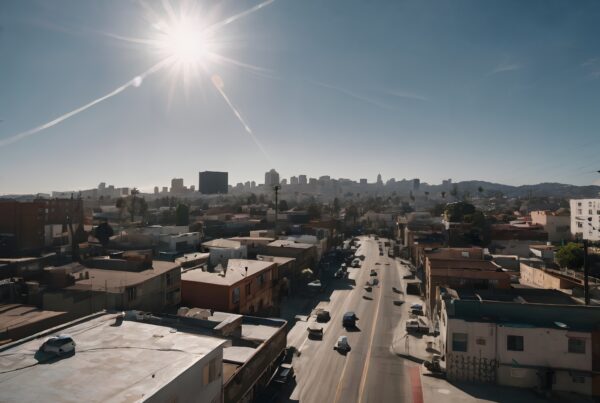 Vibrant cityscape with sunlit skyline and busy street.