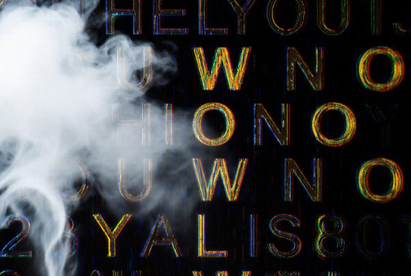 Colorful glitch text partially obscured by swirling white smoke on a black background.