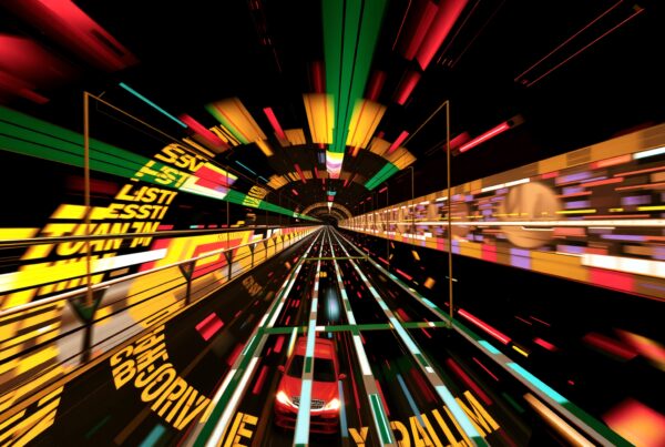 This image depicts a futuristic tunnel with vibrant, colorful lights and graphics, creating an immersive visual experience.