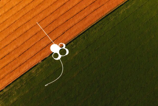Aerial image showing contrasting orange and green farmlands with white circular design elements.