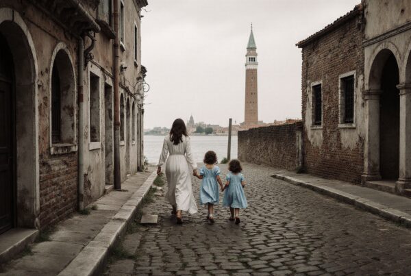 A woman and two girls walking down a charming cobblestone street with historic buildings.