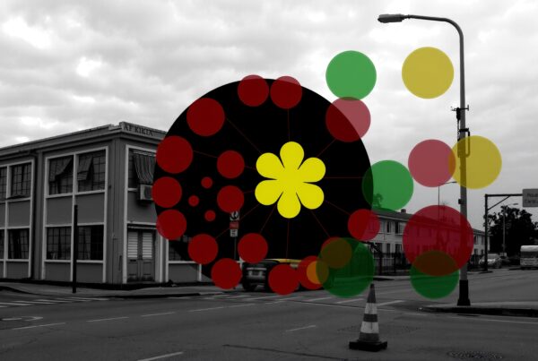Grayscale urban street scene with colorful abstract overlay featuring circles and a flower-like design.