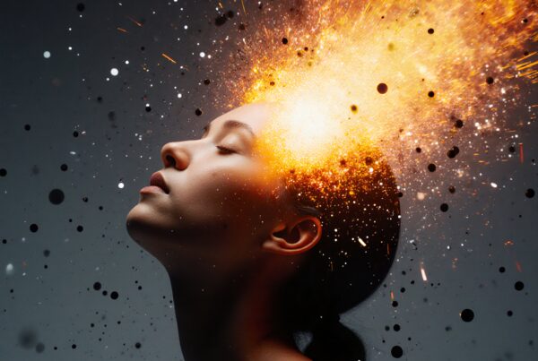 A woman with eyes closed, emitting a vibrant explosion of orange and yellow light, symbolizing creativity.