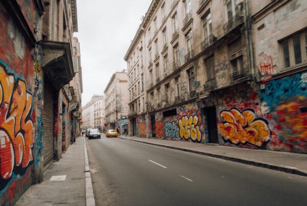 Urban street with vibrant graffiti-covered buildings.
