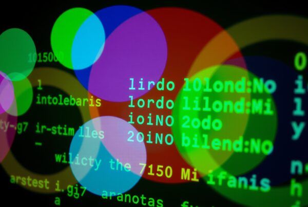 Abstract digital art with colorful circles overlaying green alphanumeric code.