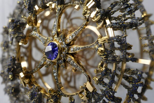 Intricate gold and sapphire jewelry piece with diamonds and floral design.