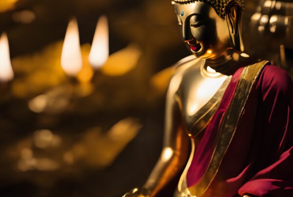 Golden Buddha statue draped in maroon robe meditating peacefully with warm, soft lighting.